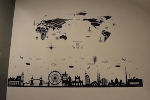 A world map with iconic landmarks and a silhouette of famous buildings at the bottom.