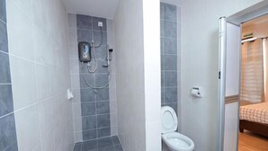 A bathroom with a shower, toilet, and a bed in the adjacent room. - De cozy Homestay (8-14 pax) (Ipoh)
