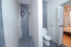 A bathroom with a shower, toilet, and a bed in the adjacent room. - De cozy Homestay (8-14 pax) (Ipoh)
