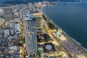 A coastal cityscape with high-rise buildings, a beach, and a promenade.