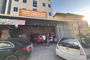 Edifício com placa de restaurante e um carro estacionado em frente.