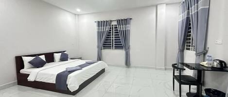 Un dormitorio con cama, escritorio y silla.