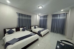 A hotel room with two beds, a small table, and curtains on the windows. - Rosi Guesthouse & Coffee3 (Sihanoukville)