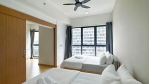 A hotel room with two beds, a ceiling fan, a large window with curtains, and a view of a cityscape. - D'Sara Sentral Condo (Petaling Jaya)