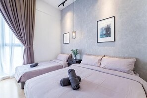 Een moderne hotelkamer met twee bedden, een nachtkastje, een wandlamp en kunstwerken in lijsten.
