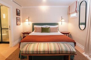 A bedroom with a bed, bedside tables, a bench, a mirror, and wall-mounted lights. - Valverde Santar Hotel & SPA (Santar)