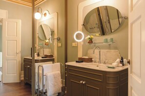 Une salle de bain avec un meuble-lavabo double, un grand miroir et un anneau lumineux.