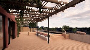 A wooden deck with a pergola, seating areas, and a view of the cityscape. - Valverde Santar Hotel & SPA (Santar)
