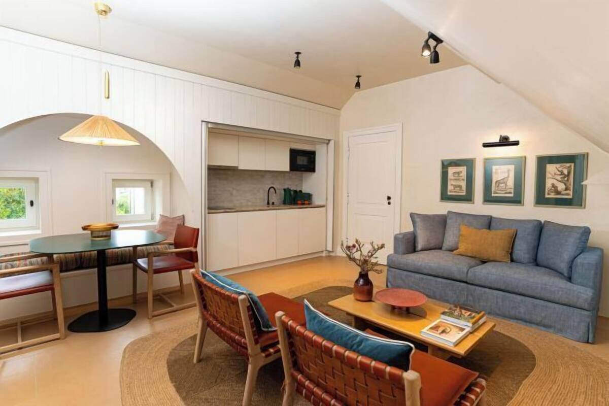 A compact living space with a dining area, a sofa, and a kitchen.