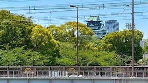 A bridge with a traditional Japanese architectural structure in the background. - Seishukugawa (Osaka)