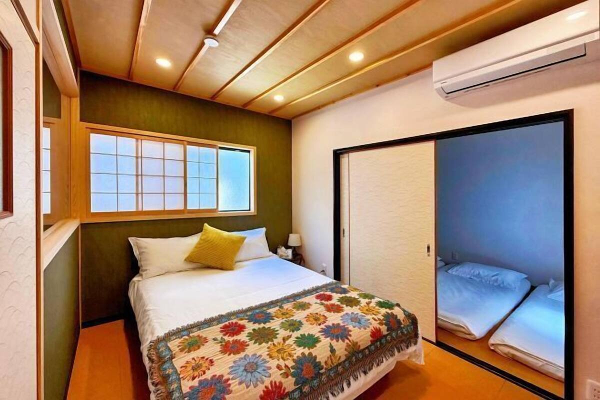 A bedroom with a bed, a window, and a sliding door.