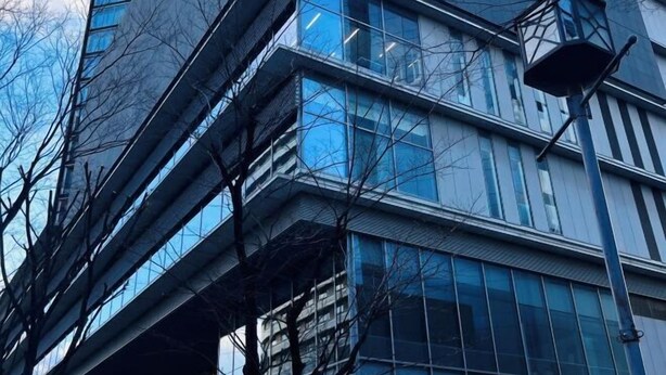 A modern building with multiple floors, large windows, and a street lamp. - Seishukugawa (Osaka)