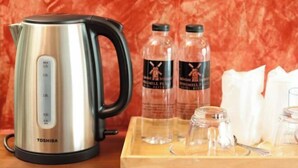 A stainless steel Toshiba kettle, two bottles with insect labels, a wooden tray with glassware, and a white napkin holder. - Windmill Place Khaoyai (Pak Chong)
