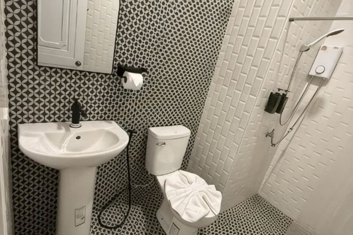 A bathroom with a sink, toilet, and shower.