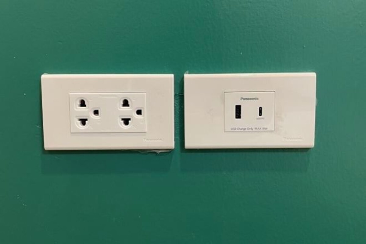Two electrical outlets on a green wall.