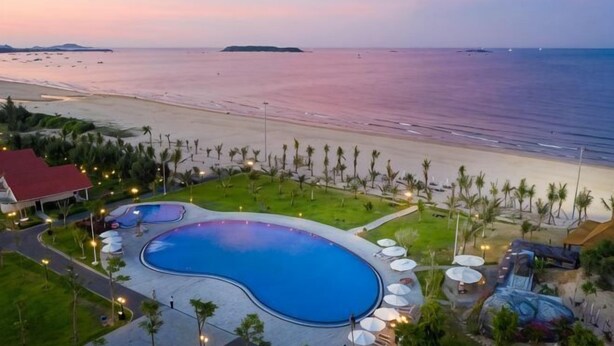A resort with a large swimming pool, beach access, and palm trees. - Sao Mai Resort (Tuy Hoa)