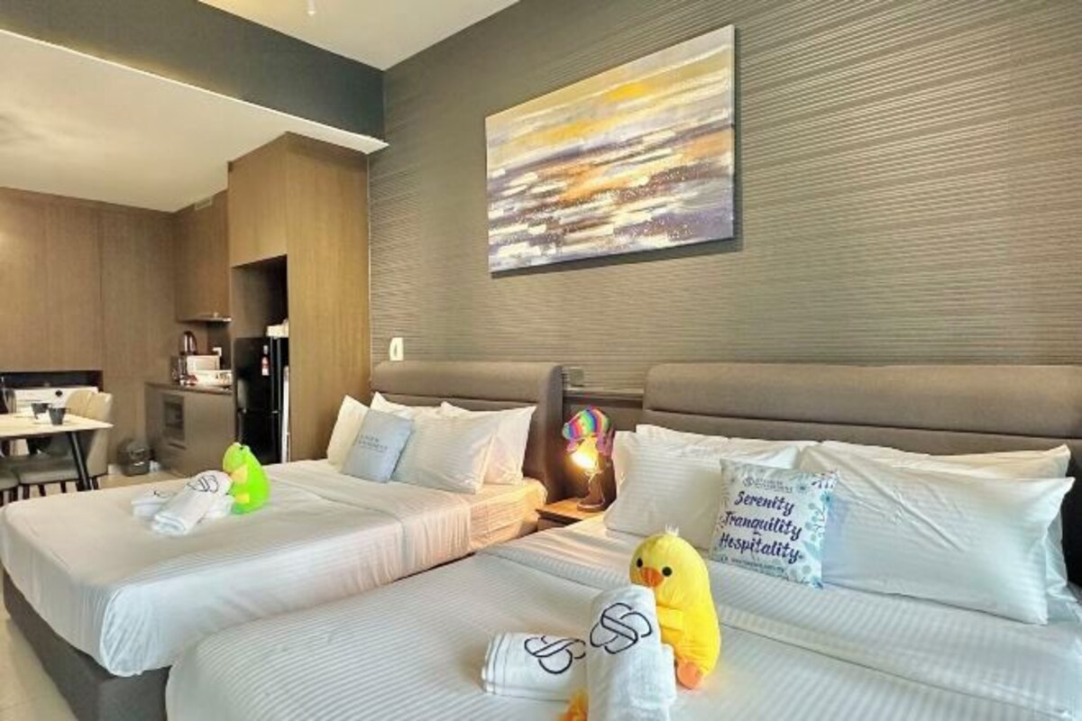 Habitación de hotel con dos camas, un escritorio y un cuadro en la pared.