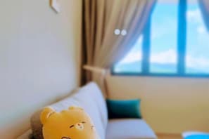 Una habitación con sofá y ventana con cortinas.