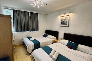 Une chambre d’hôtel avec deux lits, une armoire, une fenêtre avec des rideaux, une table de chevet et un tableau au mur.