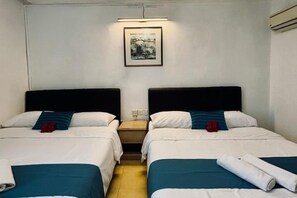 Une chambre d’hôtel avec deux lits simples, une table de chevet, un tableau accroché au mur et une fenêtre.