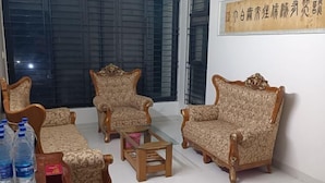 A living room with two patterned sofas, a wooden coffee table, and a small table with bottled water.