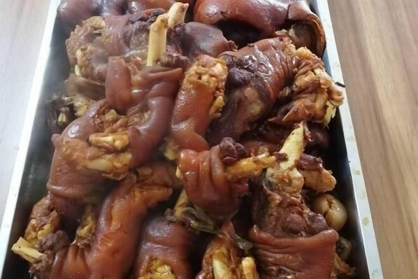 Uma travessa com salsichas cozidas, com ossos e recheio visíveis.