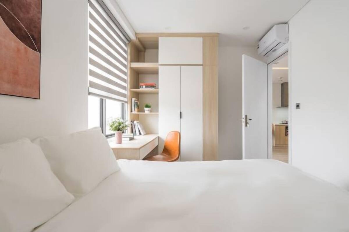Ein modernes Schlafzimmer mit Bett, Schreibtisch, Stuhl und Kleiderschrank.