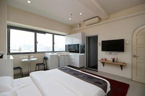 A hotel room with a bed, a desk, a TV, and a window. - JJH Serviced Apartments Near Serangoon MRT (Singapore)
