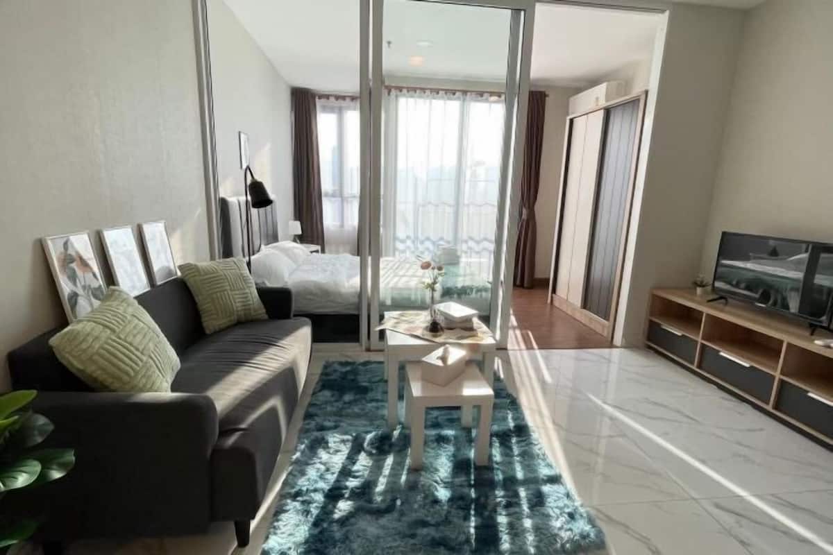 A modern living room with a sofa, a coffee table, and a TV stand.