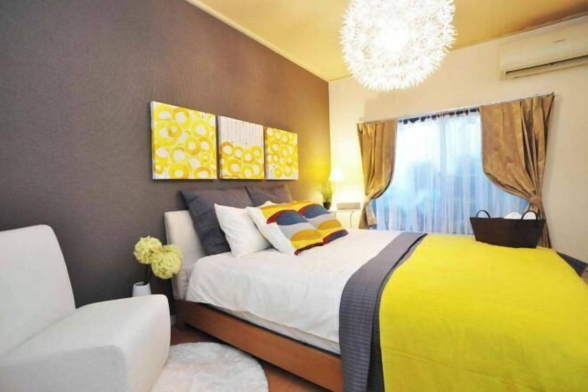 Une chambre à coucher comprenant un lit, une table de chevet, une chaise et un élément décoratif mural.