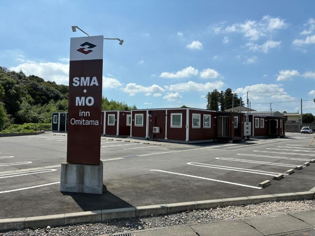 En parkeringsplads med skilt for SMA MO Inn Omitama.