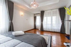 A hotel room with a large bed, a chandelier, and a view of the outdoors. - tropical private pool villa (Bangkok)