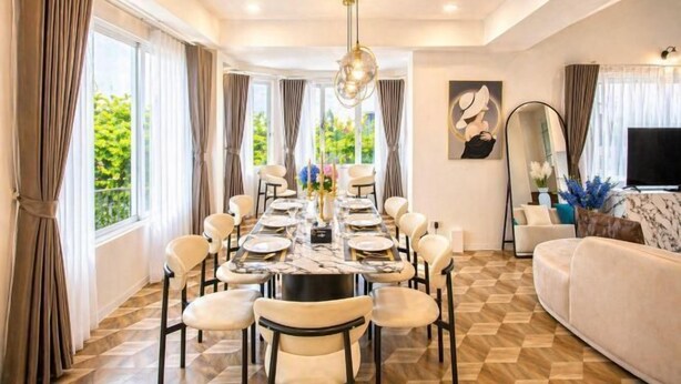 A dining area with a round table, chairs, and a chandelier. - tropical private pool villa (Bangkok)
