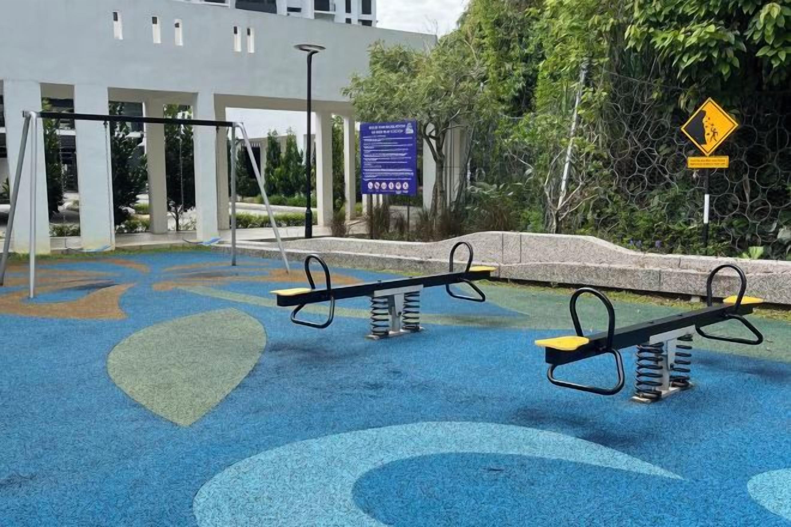 Un'area giochi con altalene e una superficie in gomma blu.