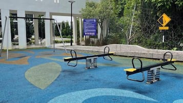 Un'area giochi con altalene e una superficie in gomma blu.