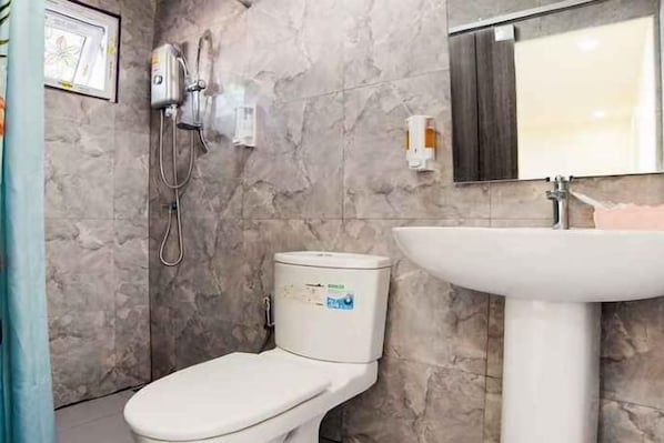 A bathroom with a toilet, a sink, and a shower unit. - 5 Diamond (Bangkok)