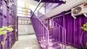 A purple staircase in a hallway with a ceiling fan and a plant. - 5 Diamond (Bangkok)