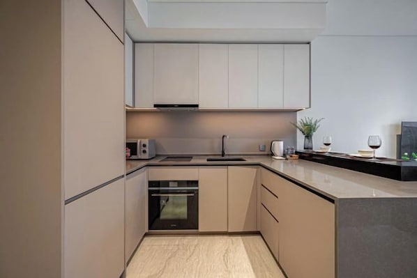 A modern kitchen with built-in appliances, a countertop, and a backsplash.
