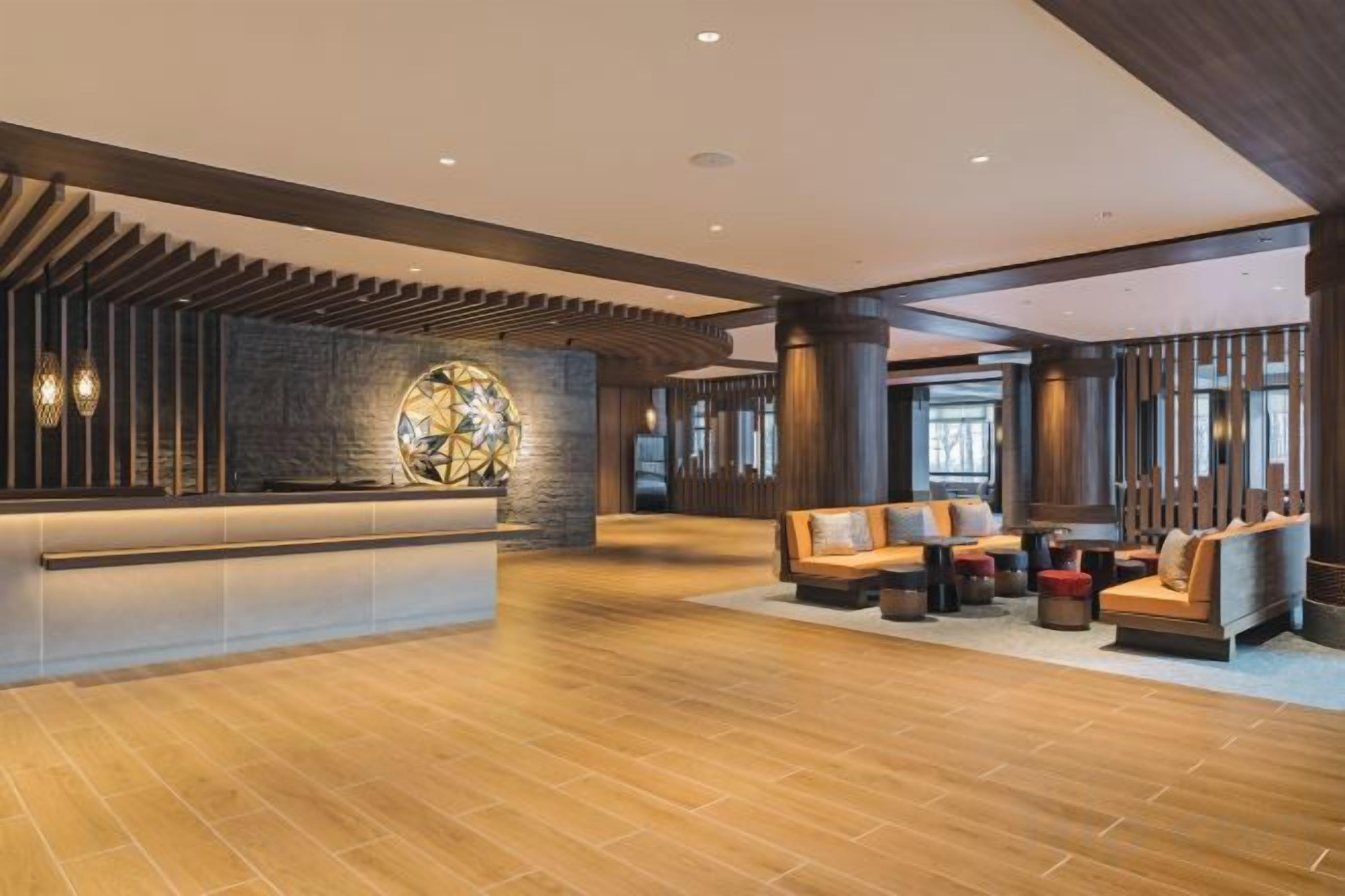 A spacious lobby with a reception desk, seating area, and large windows allowing natural light.