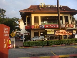 Un restaurant McDonald's avec une enseigne indiquant qu’il est ouvert 24 heures sur 24.