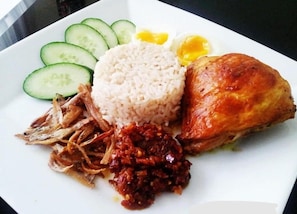 A plate of food with rice, a fried egg, cucumber slices, and a piece of meat. - Swing & Pillows @ KL Pekeliling (Kuala Lumpur)