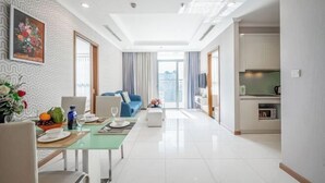 Uma sala de estar moderna com área de jantar, cozinha e vista da cidade.
