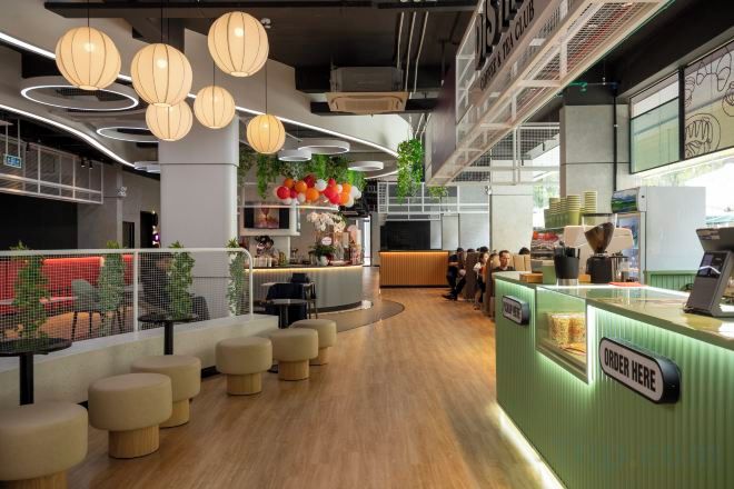 Un intérieur moderne comprenant un espace salon, un comptoir avec une enseigne et un escalier.