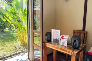 A room with a wooden table, a window, and a view of greenery outside. - Fontainebleaulaos (Luang Prabang)