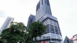 A tall, modern skyscraper with a grid-like facade and a prominent corner entrance. - Mona Homes #6 Macalister 218, Georgetown Penang (George Town)
