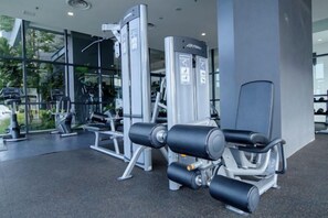 Un gimnasio con equipo de ejercicio, que incluye una máquina de prensa de piernas y una máquina de remo sentado.