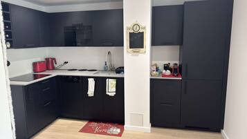 Een koelkast, een vaatwasser, kookgerei, borden en bestek