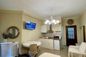 A compact living space with a dining area, kitchenette, and a small seating area. - Barbi's Home- Colli Albani Roma (Rome)