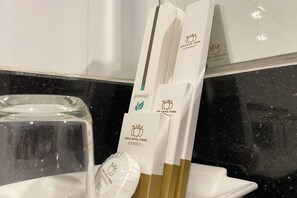 A set of white and gold hotel brochures with a logo, placed on a white tray. - Apple Hotel Two (Phnom Penh)