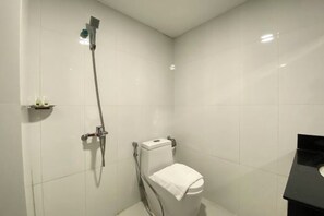 A small, modern bathroom with a toilet, a shower, and a sink. - Apple Hotel Two (Phnom Penh)